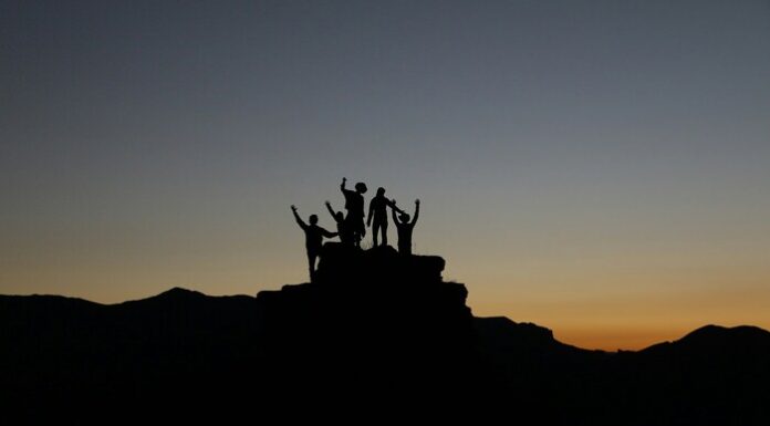 Understanding Leadership Theories image of individuals, but they are shadows due to the sunset.